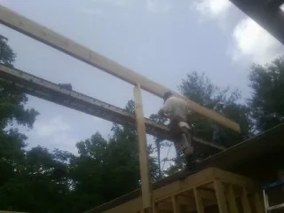 Carpenter setting a ridge beam over a new addition frame — Ice Dam Removal by Roofing Brothers in Hunt Valley