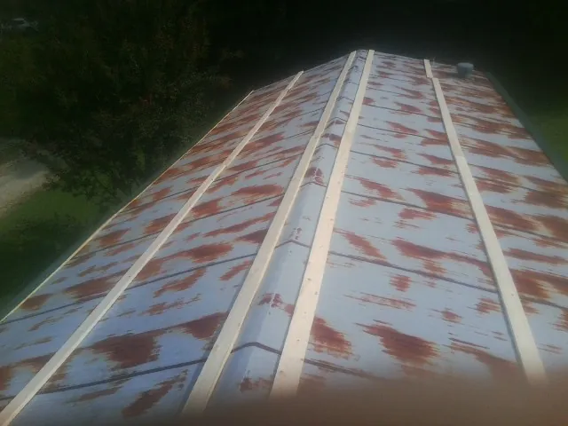 Rusted metal roof panels with new wood purlins before replacement — Storm Damage Roof Repair in Hunt Valley by Roofing Brothers