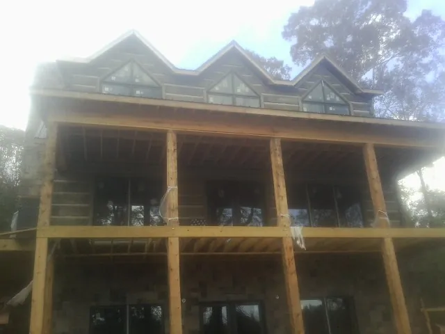Dormers and porch framing on a large log home under construction — Roof Coating work by our crew in Hunt Valley