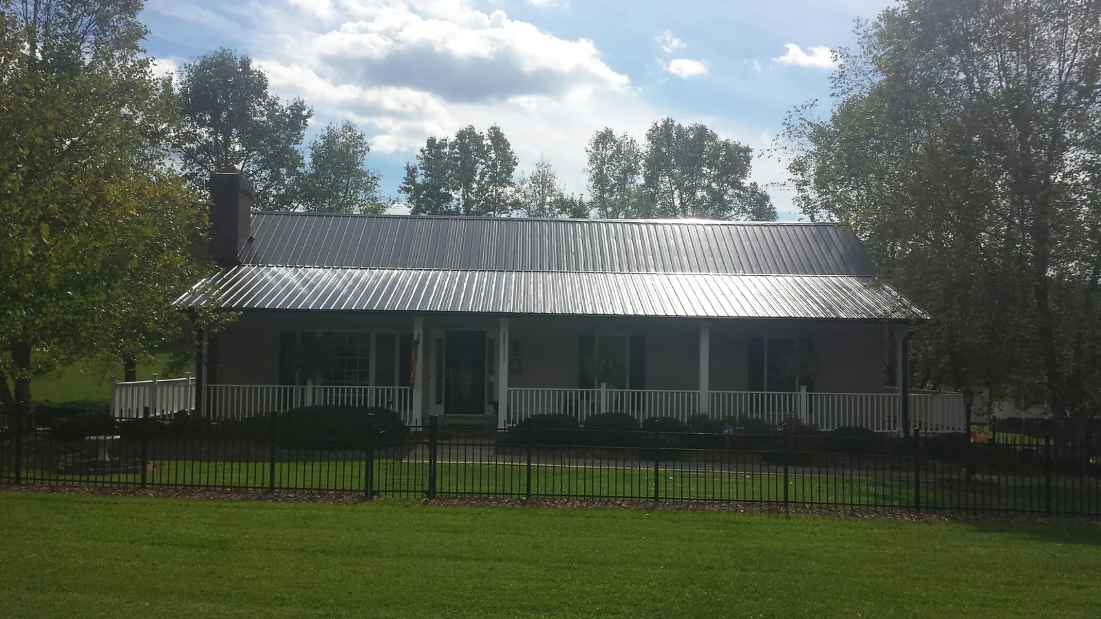 Gray metal roof on a brick ranch with a full width front porch — Gutter Guard Installation work by our crew in Hunt Valley