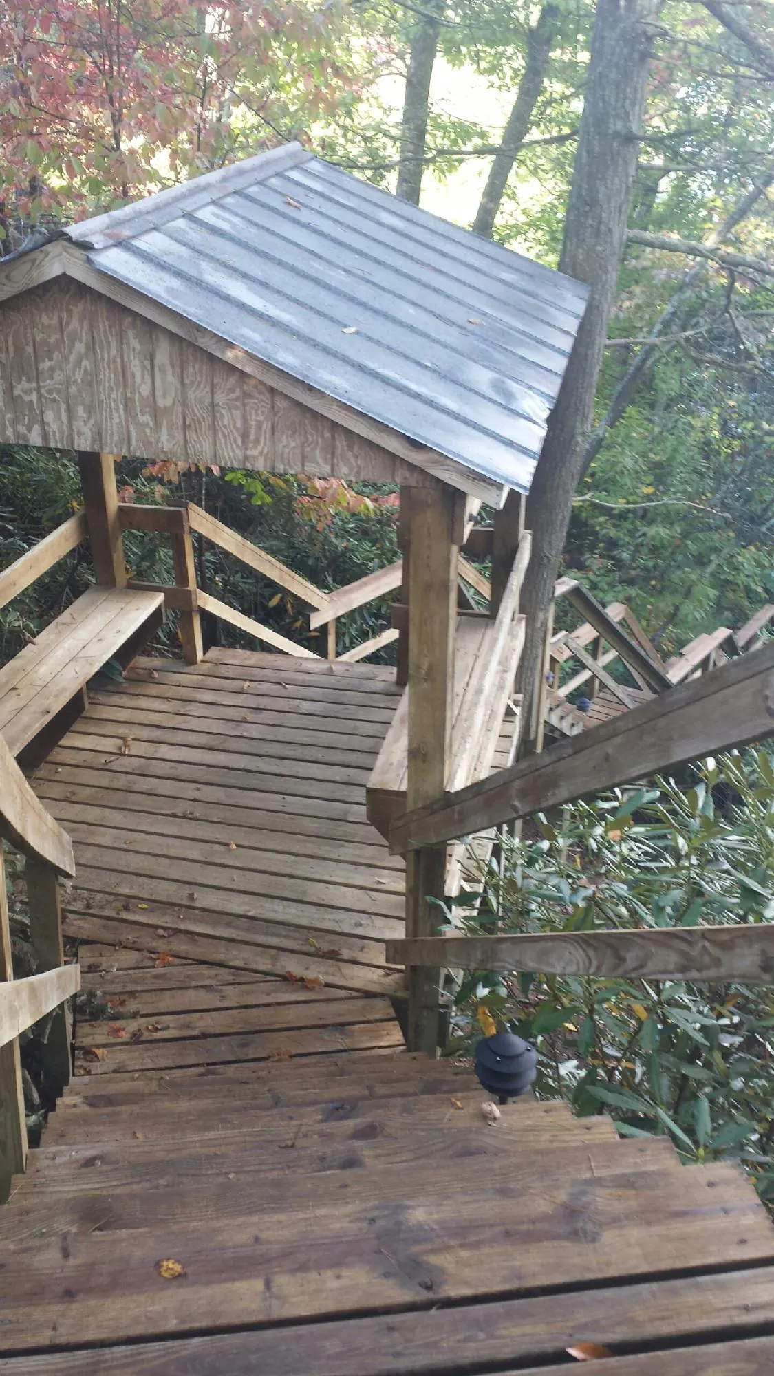 Metal roofed shelter over wooden steps on a wooded walkway — Skylight Repair & Installation work by our crew in Hunt Valley
